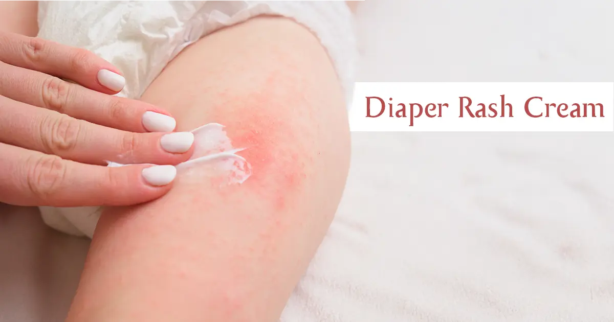 A mother applying diaper rash cream to her baby