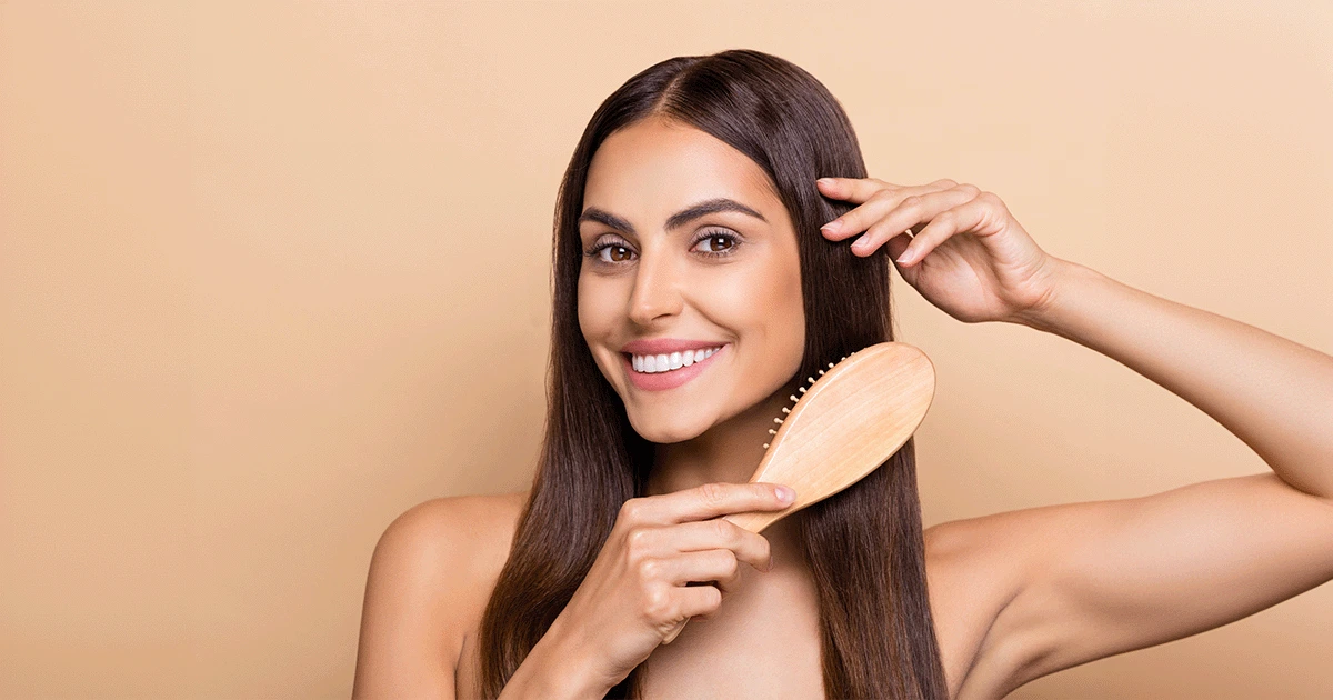A smiling women doing a hair brushing 