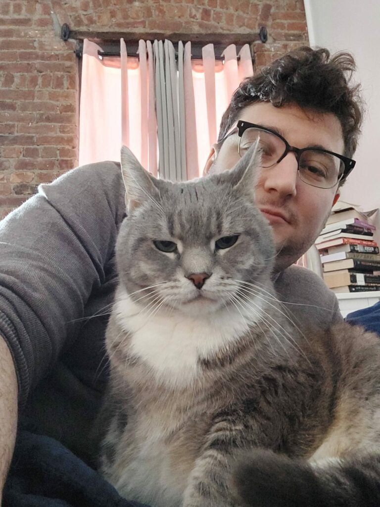 a man is holding a cat in his arms.