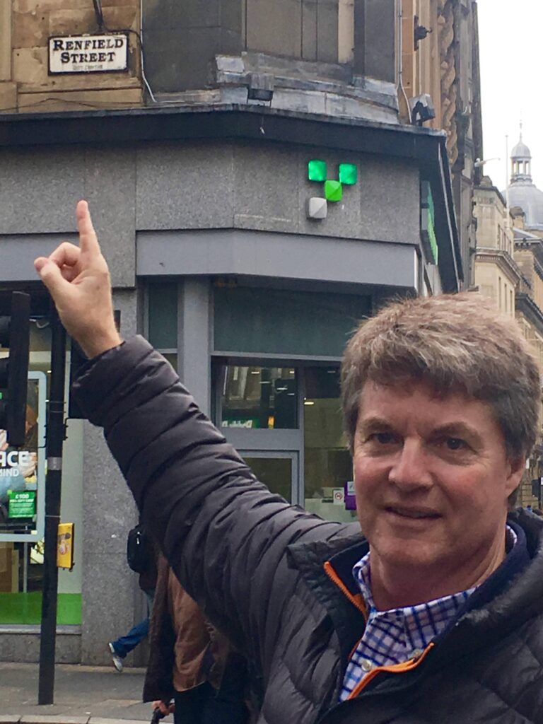 a man is pointing at a sign in front of a building.