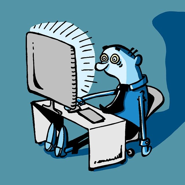 Exhausted man staring at a computer screen.