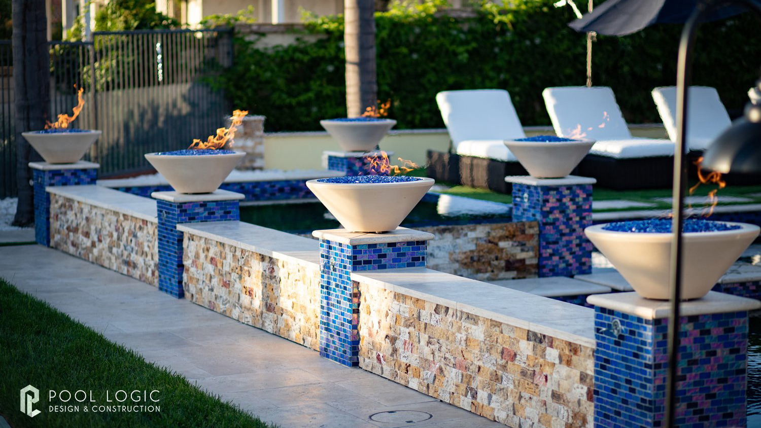 Pool fire bowls beside swimming pool