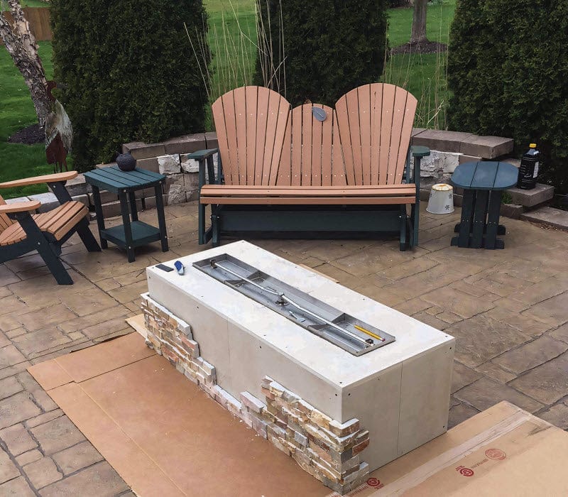 Custom gas fire pit enclosure installed in an outdoor patio