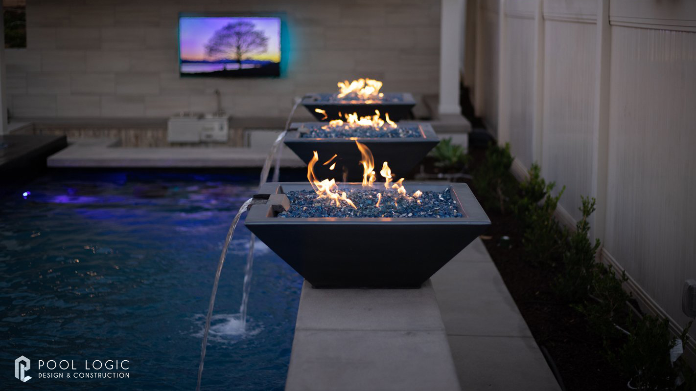 Modern fire and water bowls beside pool