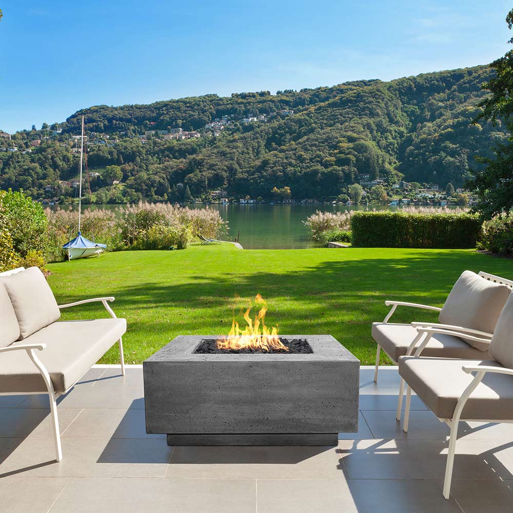 Prism Hardscapes Tavola 42 concrete gas fire pit in an outdoor patio setting