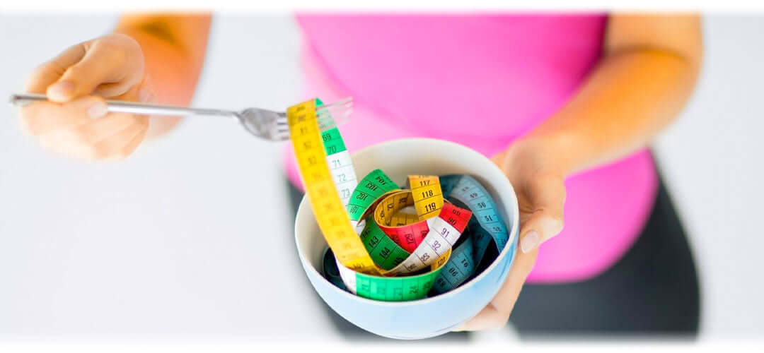 Image showing a person eating some measuring tapes, symbolising weight management