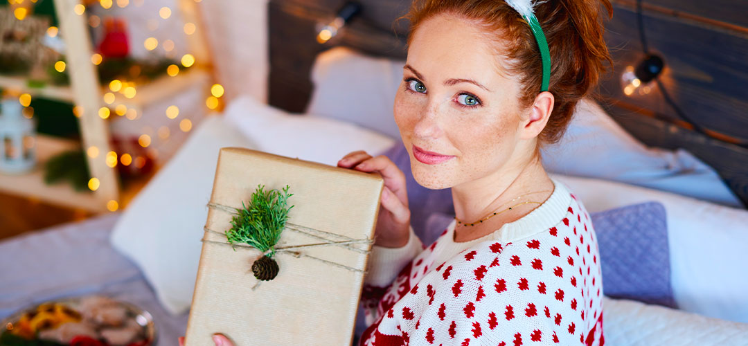 lady receiving and opening a christmas present