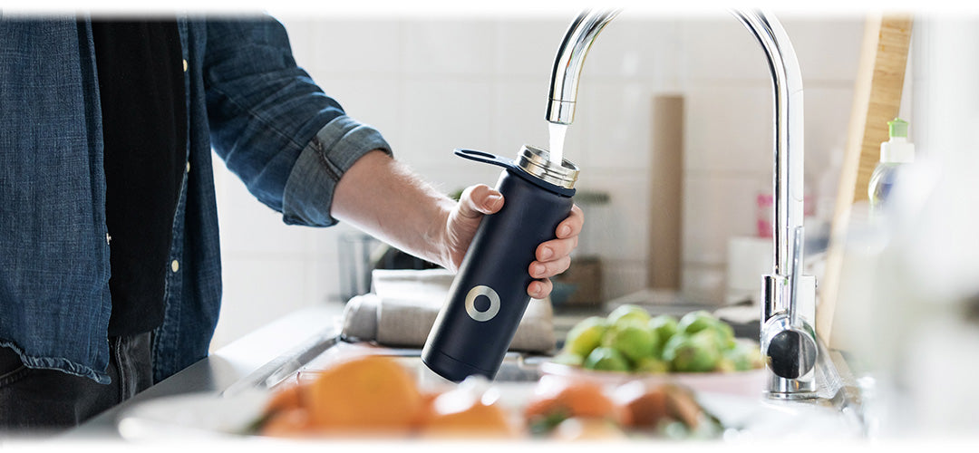 A man filling up his water bottle at the tap