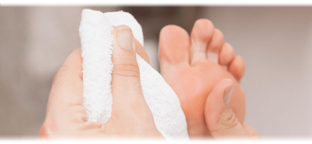 A person washing their feet with a fluffy white towel