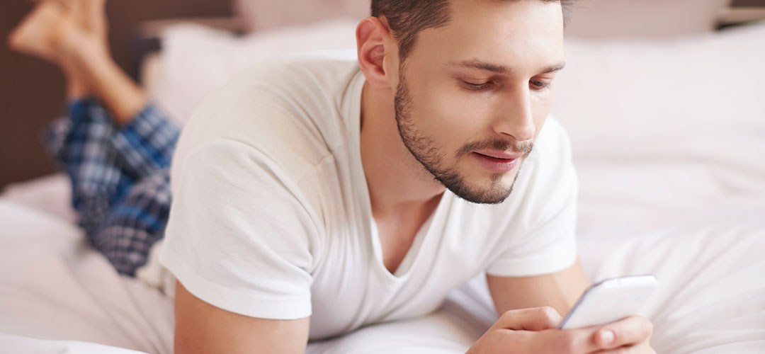 man on phone in bed
