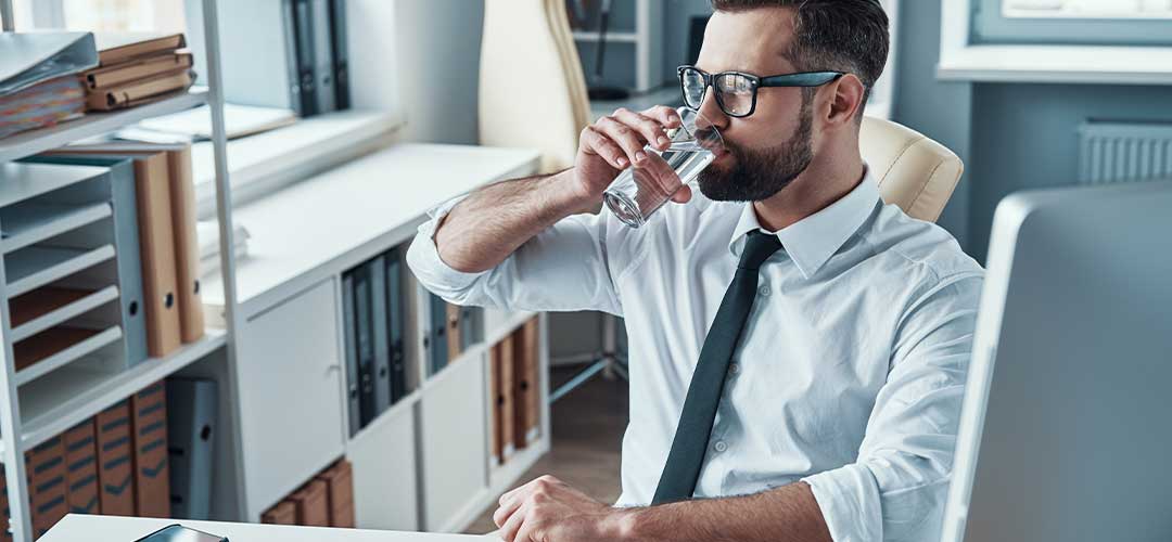 Male in office drinking glass of water