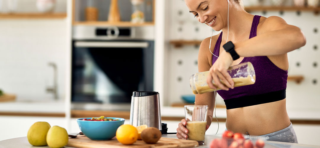 female happy making a healthy protein shake