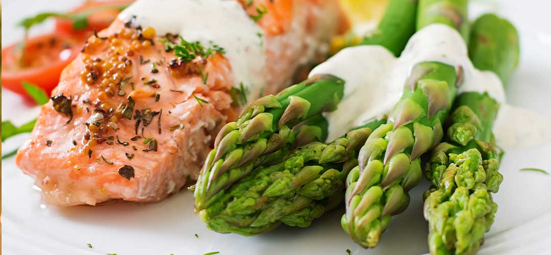 salmon garnished with asparagus and tomatoes with herbs