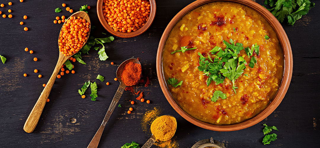 indian-dhal-spicy-curry-bowl-spices-herbs-rustic-black-wooden-table
