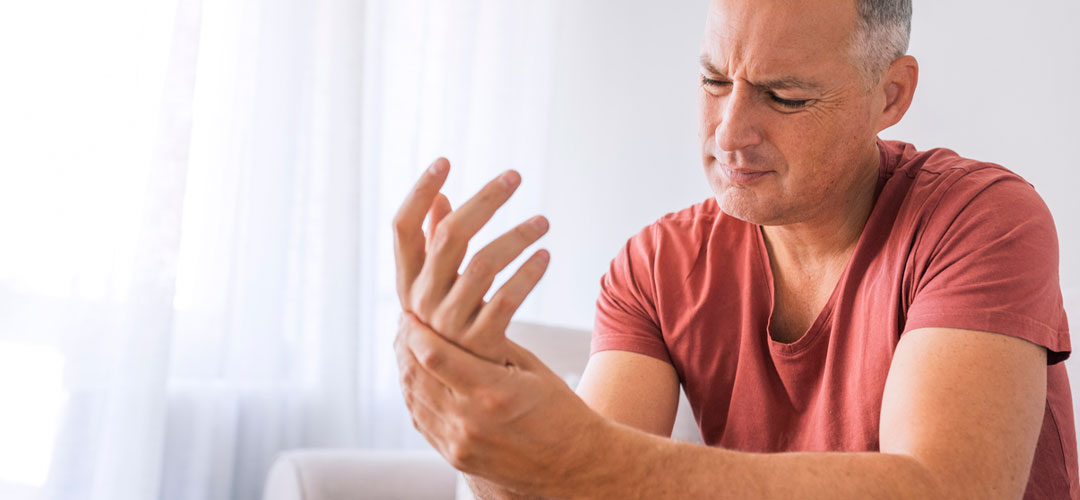 male with Rheumatoid Arthritis holding hand in pain