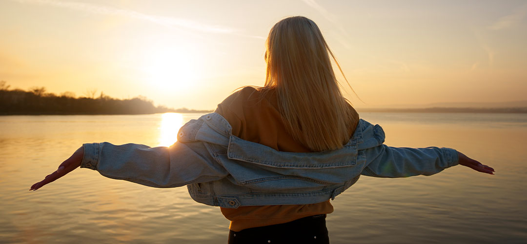 A woman enjoying watching the sunset on a beach