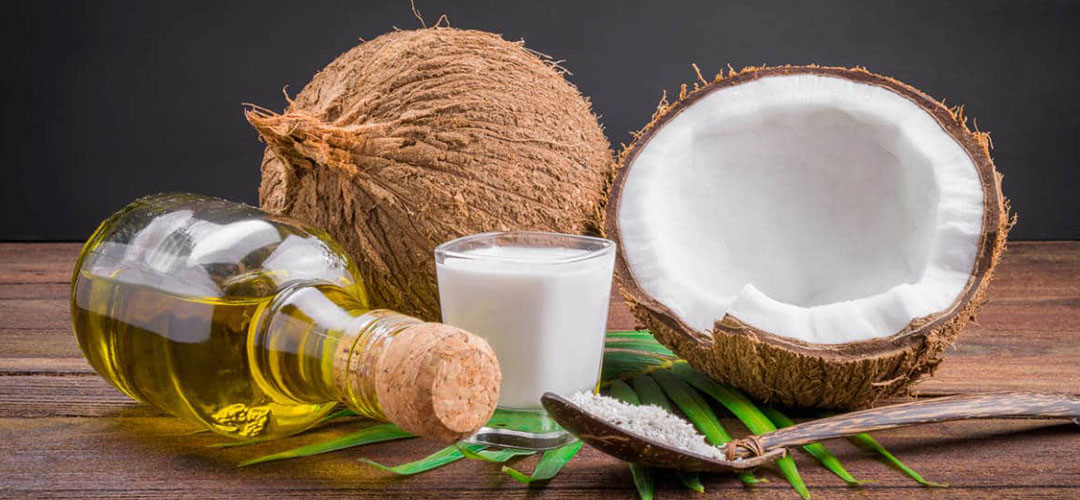 coconuts on a table next to the extracted oil