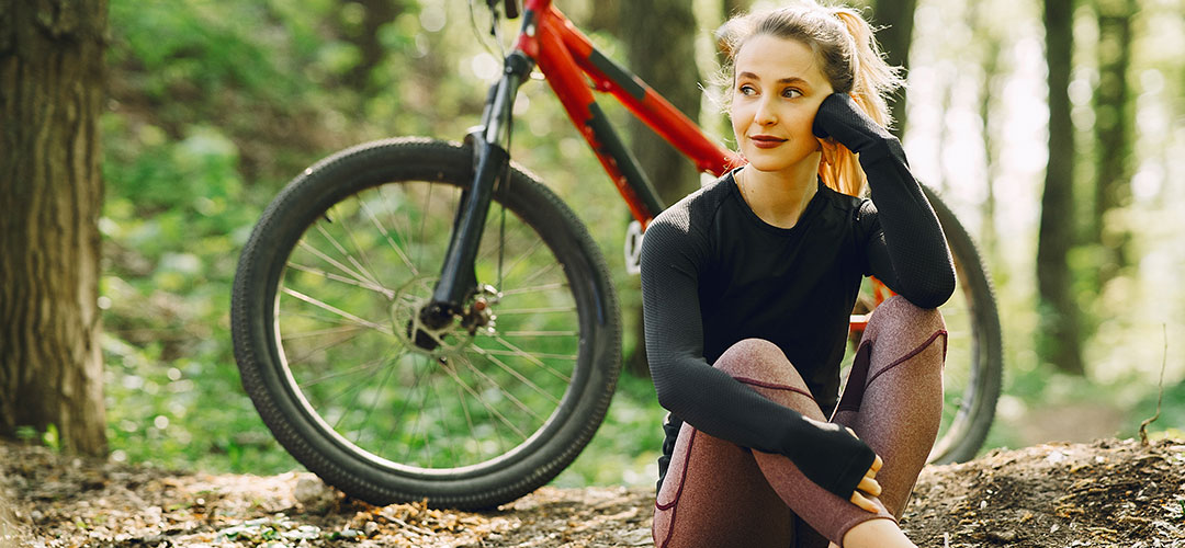 lady taking rest in forest on a cycling trail