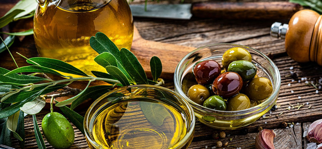 fresh olive oil on a table with fresh olives