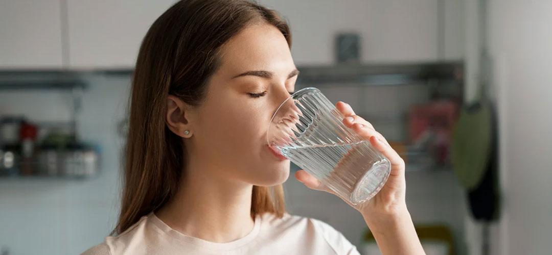 lady dribking a glass of water keeping hydrated