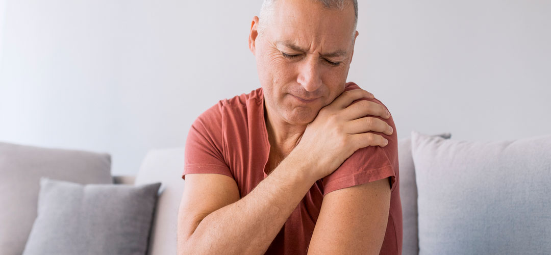 Male holding shoulder as in pain