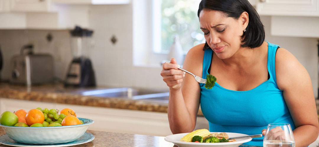 lady frowning at food as she has lost her appetite