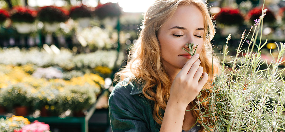 young-woman-with-beautiful-blond-hair-gentle-smile-dressed-green-robe-with-belt-is-working-greenhouse