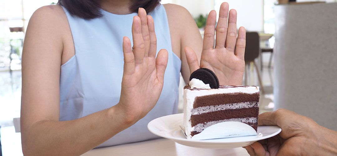women refusing cake and snacks after drinking protein