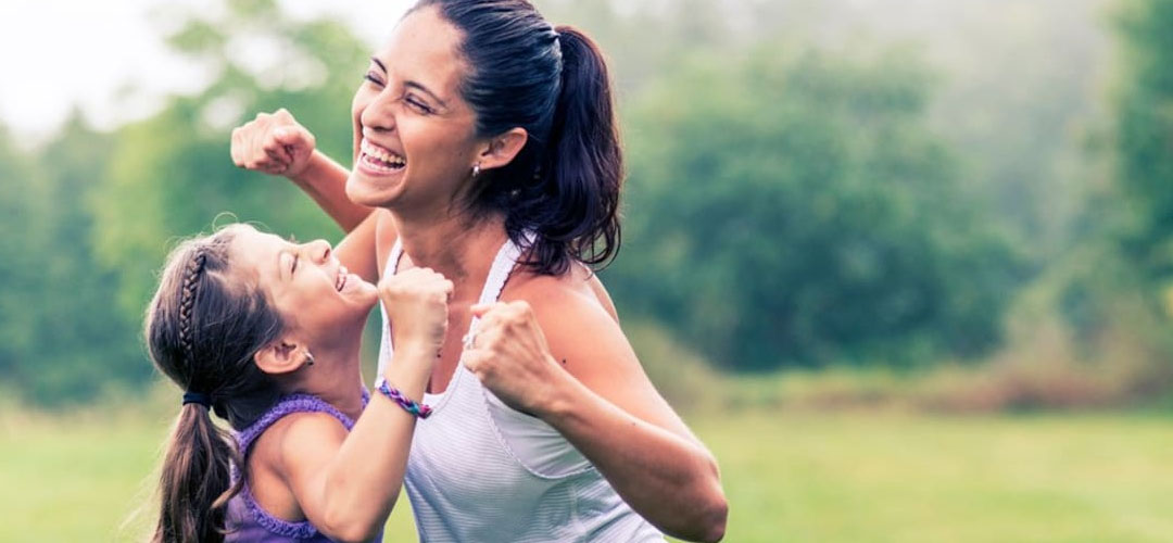 mom flexing muscles playing with daughter