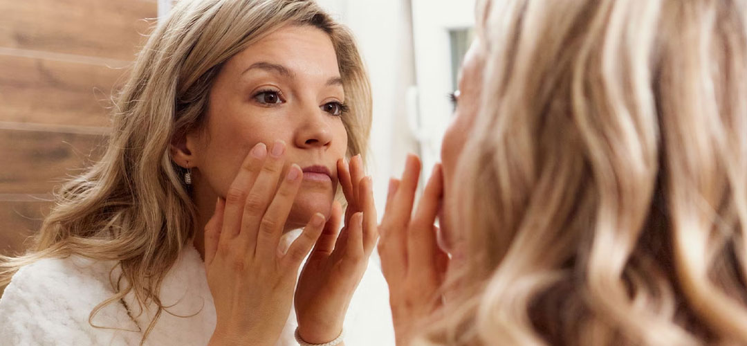 lady looking the mirror checking her skin