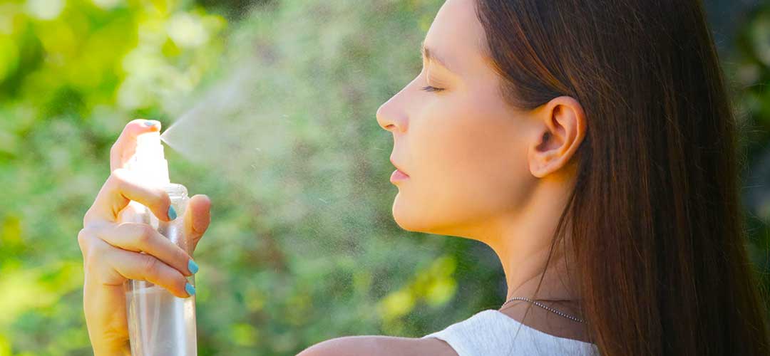 lady appling face mist of essential oils and rose water to her face