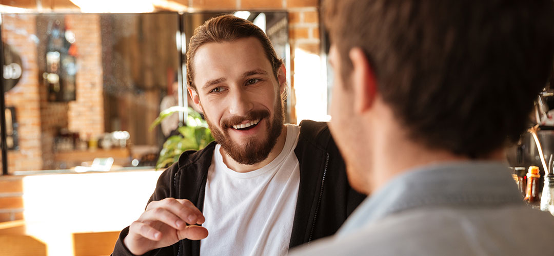 male chatting outside a cafe