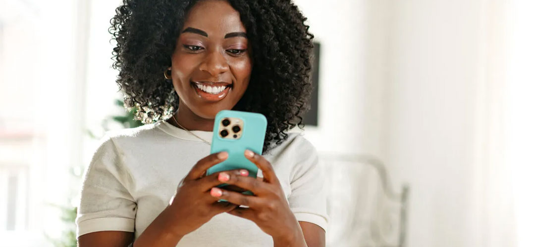 lady smiling as she looks at her mobile