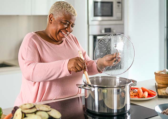 Midlife woman preparing a healthy balanced dinner with vegetables for menopause weight management