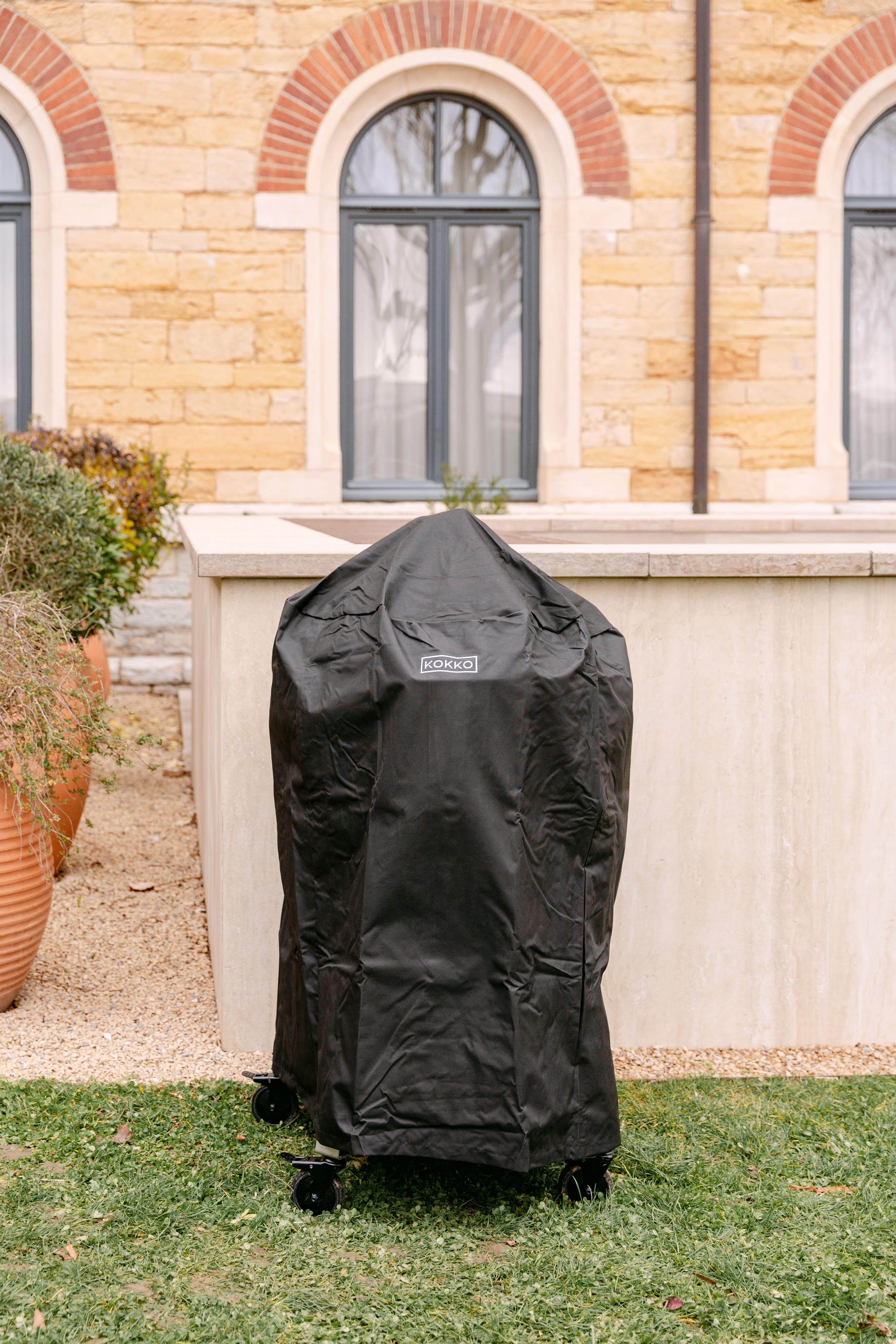 Housse de protection étanche et résistante recouvrant un Kamado Kokko, conçue pour protéger le barbecue des intempéries et prolonger sa durabilité en extérieur.