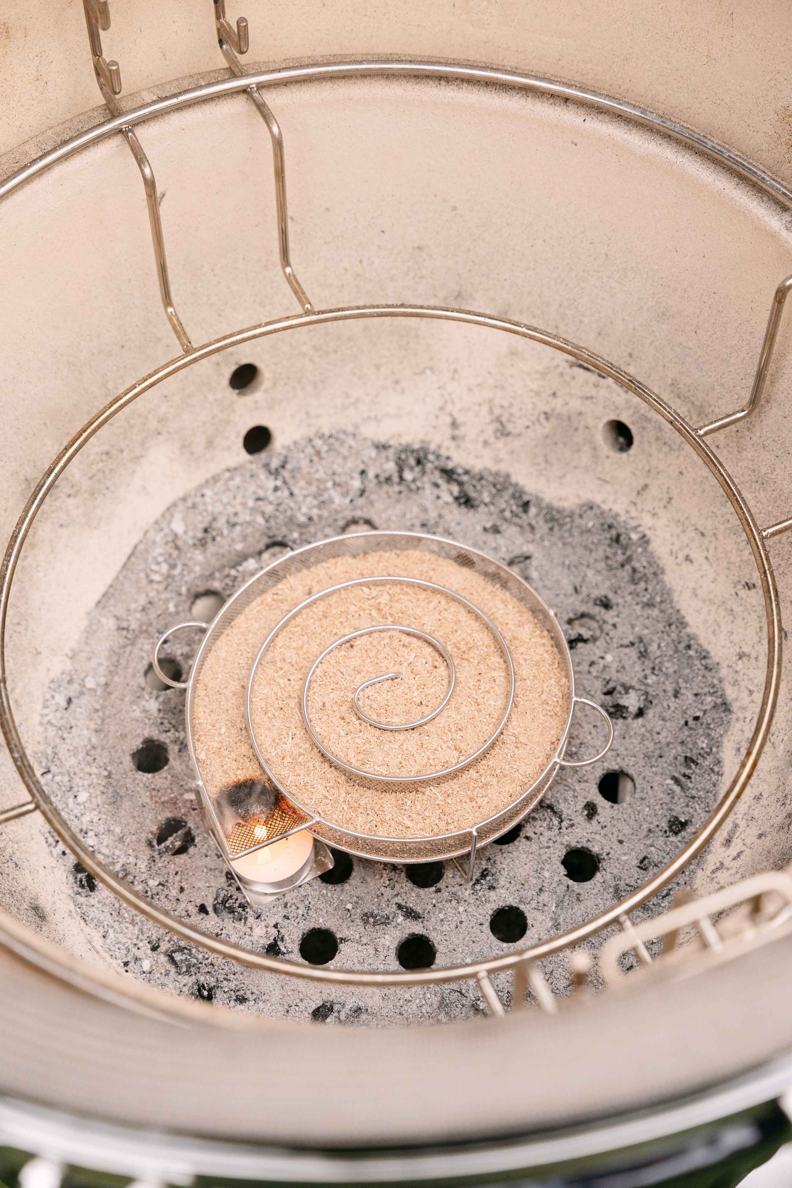 Bobina di fumo freddo con segatura accesa all'interno di un kamado Kokko