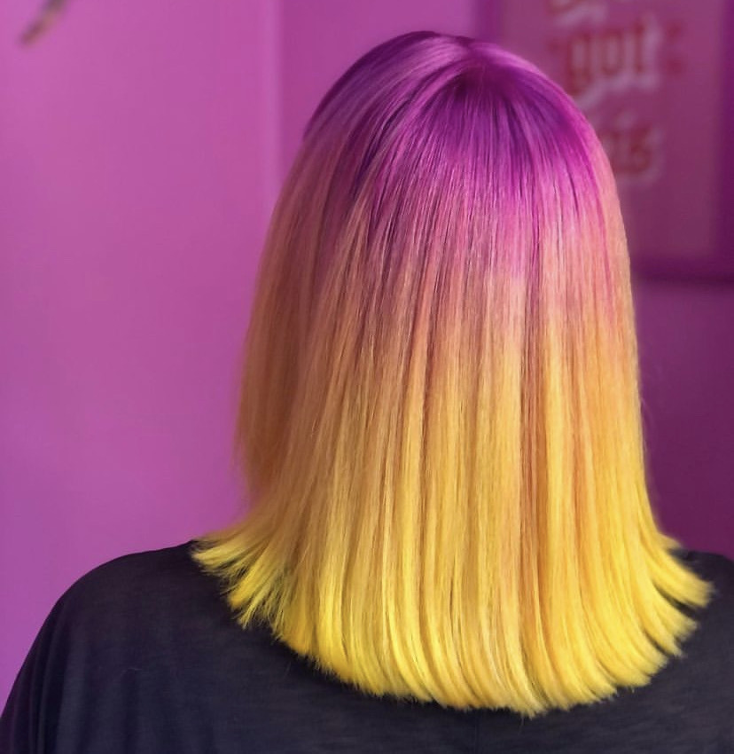back of womans head hair has pink roots and yellow ends