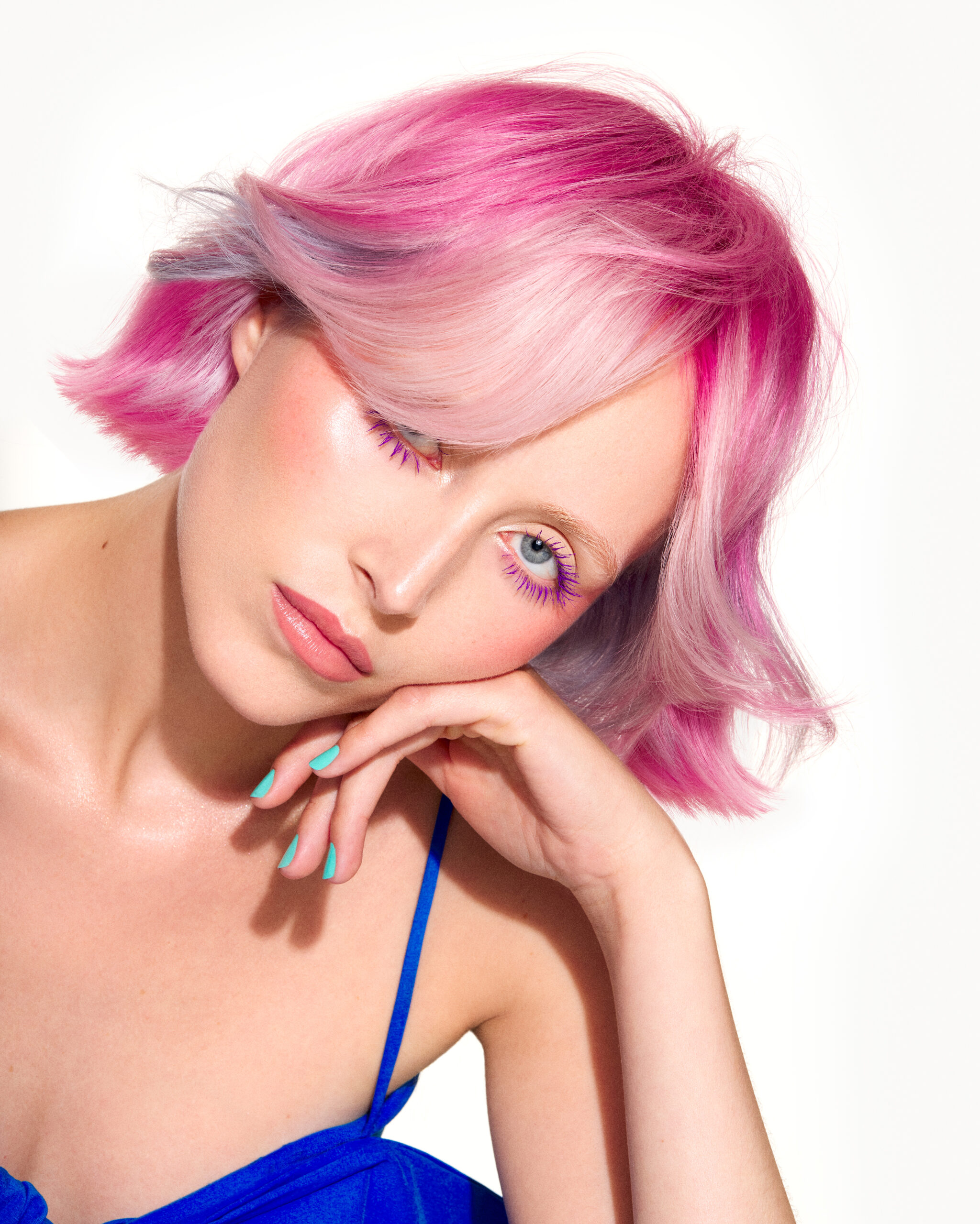 Image of model with pale pink pastel hair cut into a mob wearing a blue outfit