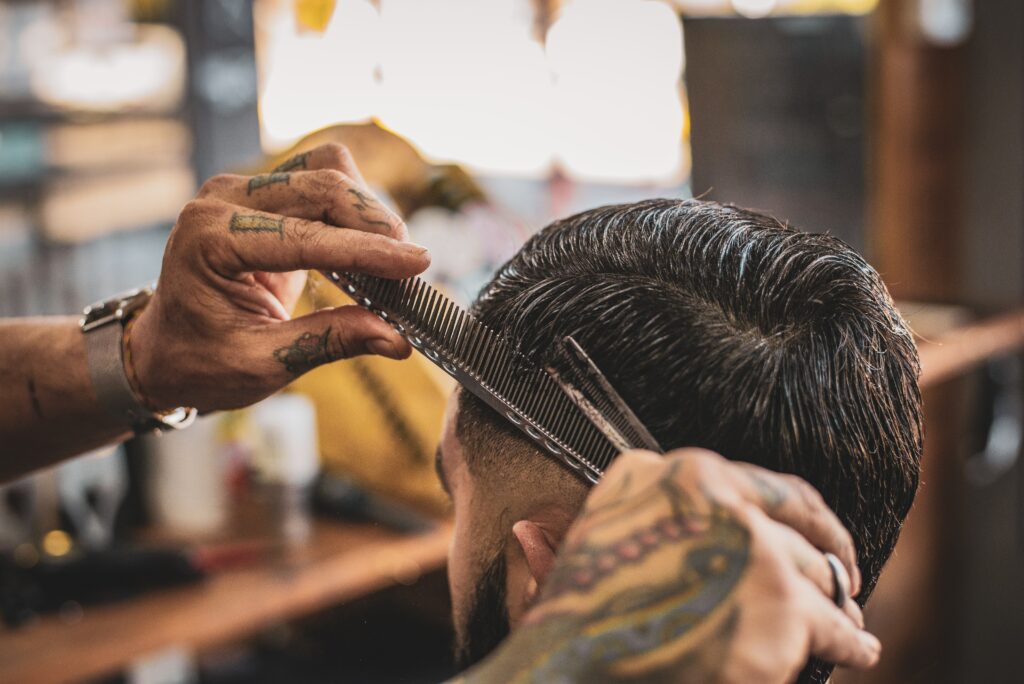 barber using a comb and shears on clients hair