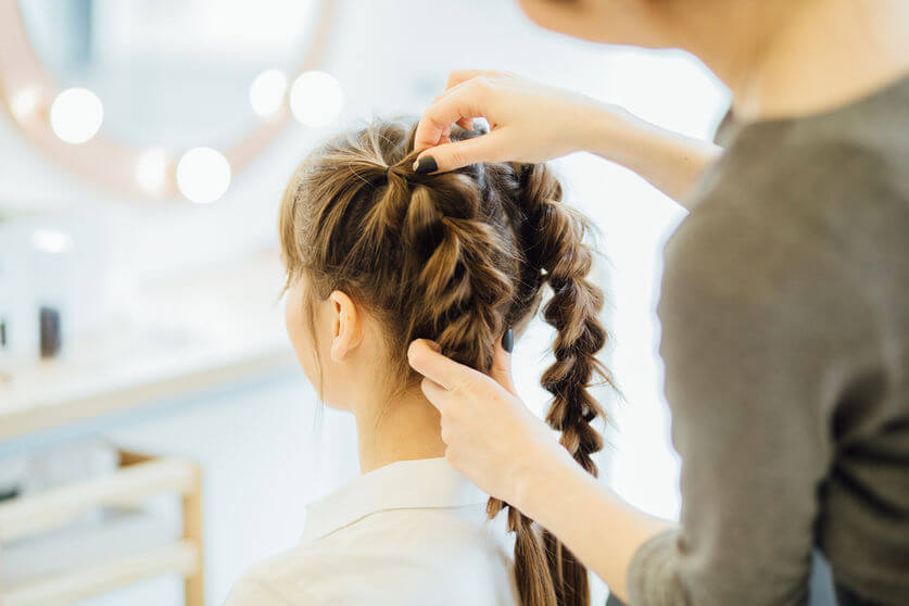 Hairdresser creating skillful hair braids