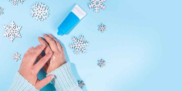 the smelly panda soap company silver snowflakes and hand cream with a blue background. female hands applying hand cream